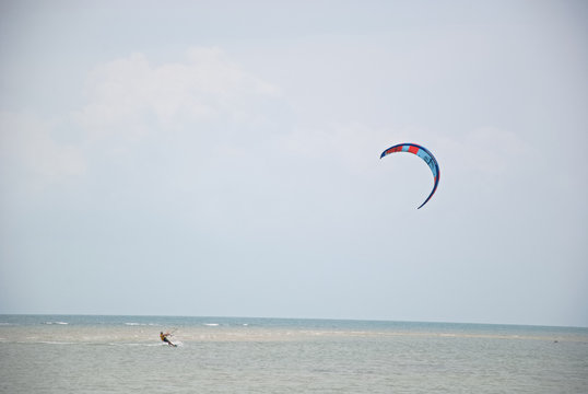 A man is kiting near a beach in Thailand