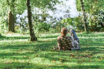Relaxing summer day in a Danish park, people lounging on the grass, pond water in the background....