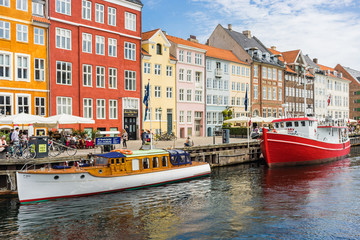 Scenic summer view of Nyhavn pier. Colorful building facades with boats and yachts in the Old Town...