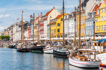 Scenic summer view of Nyhavn pier. Colorful building facades with boats and yachts in the Old Town of Copenhagen, Denmark