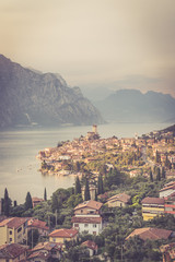 Ausblick auf Malcesine, Gardasee, Italien. Italienische Häuser, See, Berge und Plfanzen. 