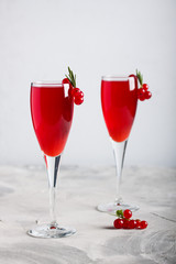 Two glasses redcurrant wine drink juice decorated with rosemary berries