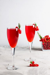 Two glasses redcurrant wine drink juice decorated with rosemary berries