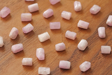 Kunzite is a natural pink stone for creating Jewelry on a natural wooden background. Natural...