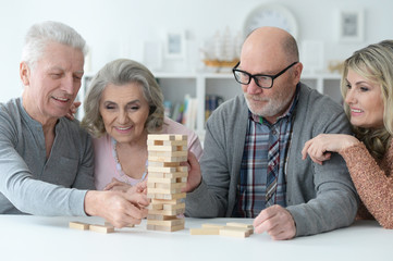 two senior couples playing with wooden blocks