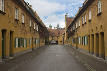 Fuggerei in Augsburg Bavaria Germany oldest social settlement in the world yellow simple attached houses donated by Jacob Fugger