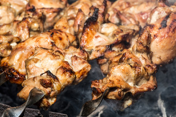 Grilled kebab cooking on metal skewer closeup. Roasted meat cooked at barbecue. BBQ fresh beef meat chop slices. Traditional eastern dish, shish kebab. Grill on charcoal and flame, picnic, street food