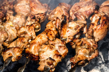 Grilled kebab cooking on metal skewer closeup. Roasted meat cooked at barbecue. BBQ fresh beef meat chop slices. Traditional eastern dish, shish kebab. Grill on charcoal and flame, picnic, street food