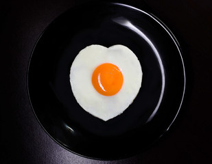 fried eggs in the shape of a heart in a frying pan