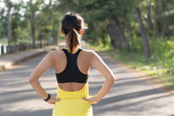 Back view of young fitness woman running on the road in the morning, People and sport concept, Selective focus