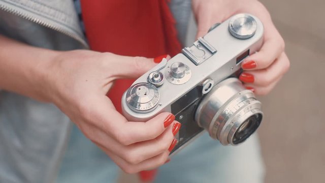 Female hands with a retro camera close-up
