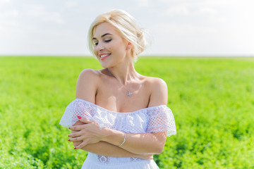 Fototapeta na wymiar Freedom concept, romantic photo of woman in green field, evening sun, Beauty Romantic Girl in white dress Outdoors. Sunshine 