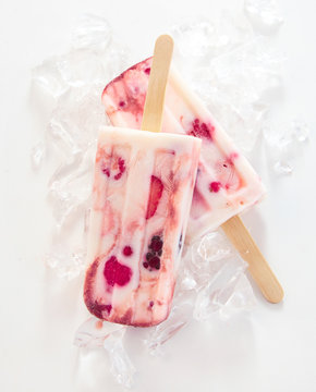 Two Frozen Yogurt And Berry Popsicles On Sticks