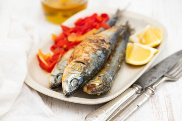 grilled sardines with red pepper and lemon on dish
