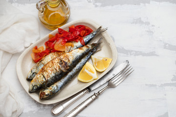 grilled sardines with red pepper and lemon on dish