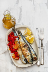 grilled sardines with red pepper and lemon on dish