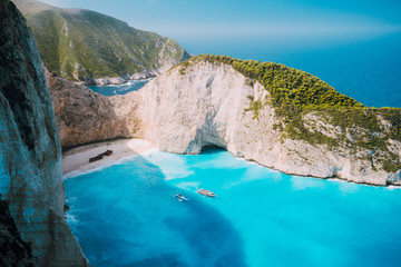 Navagio beach, Zakynthos island, Greece. Two tourist boats leaving Shipwreck bay with turquoise water and white sand beach. Famous landmark location in Greece
