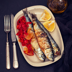grilled sardines with red pepper and lemon on dish