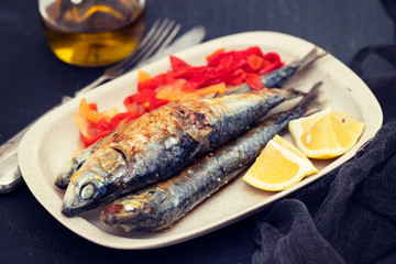 grilled sardines with red pepper and lemon on dish