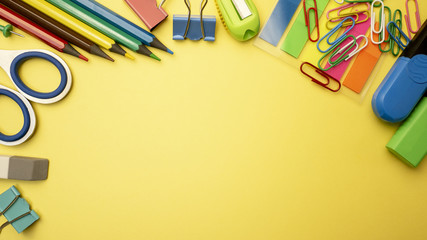 Group of school supplies on yellow background