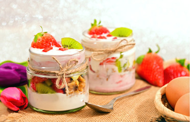 Mixed fruits and walnuts yogurt in glass with bow tie on Bokeh background..Breakfast with many kind of fruits and yogurt.
