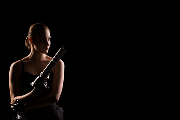 Military woman with a sport gun over black background