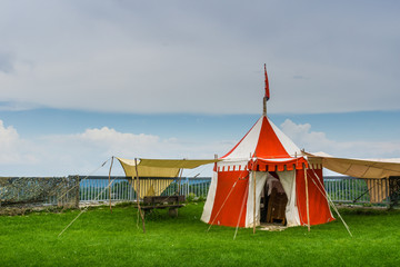 Red and white traditional tent on green meadow