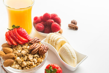 Homemade granola for healthy breakfast with berries, juice, nuts and banana