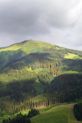 Obraz premium Rainbow over valley with Schattberg Mountain in background, Saalbach-Hinterglemm, Alps, Zell am See district, Salzburg federal state, Austria 