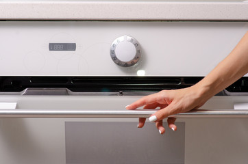 In the kitchen, the oven hob female hand interior design