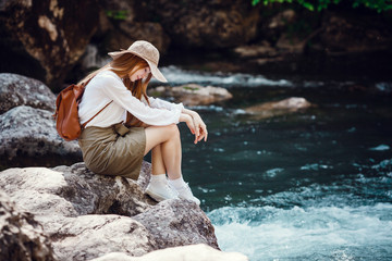 A beautiful young woman near river in the forest.