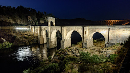 Fototapeta na wymiar Night panorama of Alcantara (Caceres, Spain) and its Roman bridge over the river Tajo
