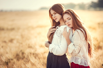 Two young women are looking forward tothe sunset. Best friends