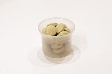 plastic beaker with tablets