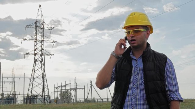 Engineer electricity talking phone during sunset