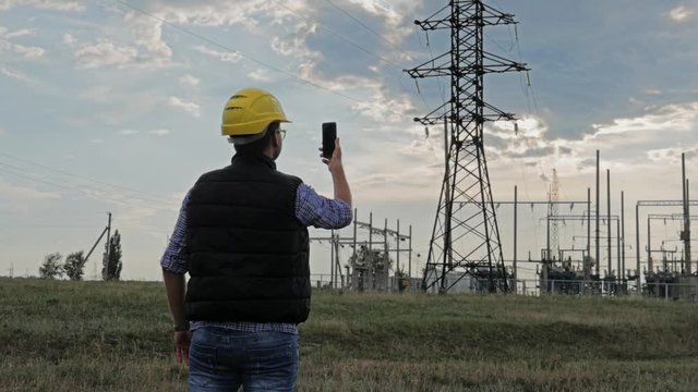 Engineer electricity use phone during sunset