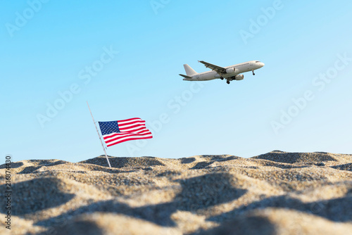 American flag in the sand against a blue sky.and plane. Concept