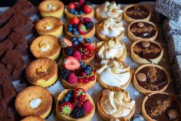 Assortment of delicious and colorful dessert, chocolate cakes, mixed berry tarts, Lemon Meringue...