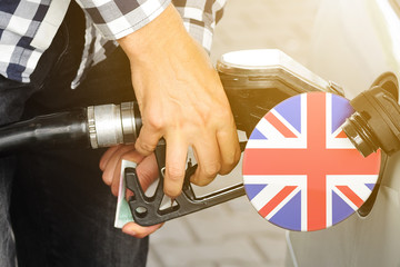 The flag of United Kingdom on the lid of the gas tank with a filling gun inserted into it