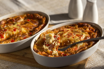 Two trays with baked omelette made from cheese, eggs, ham and red pepper