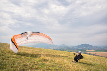 The paraglider opens his parachute before taking off from the mountain in the North Caucasus....
