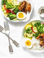Lunch served - stewed vegetables, rice, boiled egg and teriyaki chicken on light background, top view