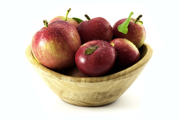 Apples with water droplets in wooden bowl isolated on white backgroun