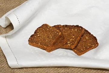 Several pieces of rye bread on white napkin