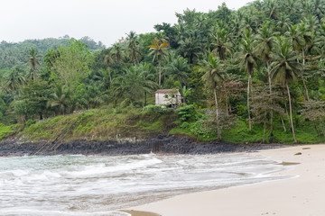 Fototapeta na wymiar Sao Tome, typical house on the beach, palm trees on the cliff 
