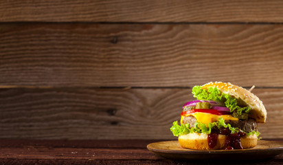 Fresh delicious burger on a wooden background