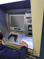 oman at an ATM cash machine.