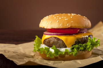 Fresh delicious burger on a wooden background