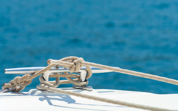 Detail image of yacht rope cleat on sailboat deck.