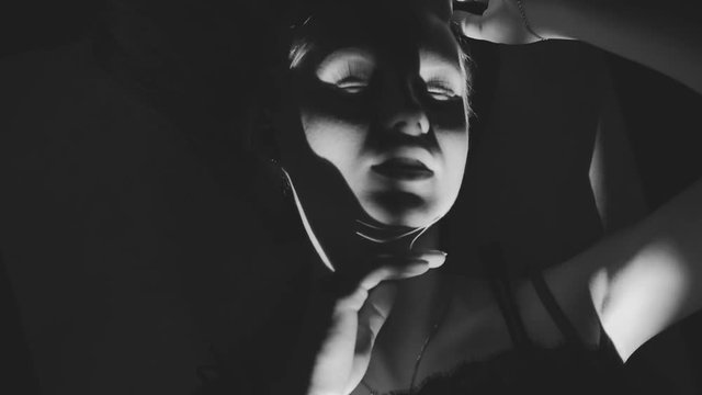 Black and white art fashion surrealistic portrait of beautiful woman with a beamof light and shadow on her face